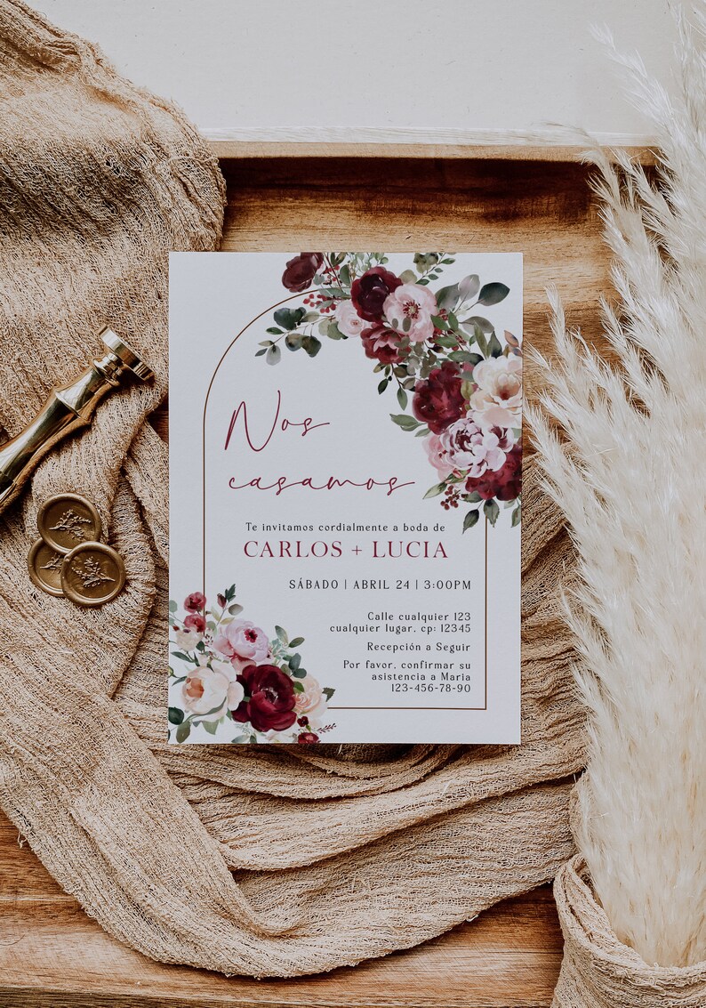 May include: A wedding invitation with a watercolor floral design in shades of burgundy, pink, and white. The text reads "Nos casamos" which translates to "We are getting married" in English. The invitation includes the names Carlos and Lucia, the date Saturday, April 24, and the time 3:00 PM. It also includes a phone number for RSVP.