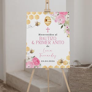 Op de afbeelding: Welkomstbord voor een doop en eerste verjaardag. Het bord toont roze rozen, bijen en honingraatmotieven. De tekst luidt "Bienvenidos al Bautizo & Primer Añito de Lucia Fernandez 24.04.202X".