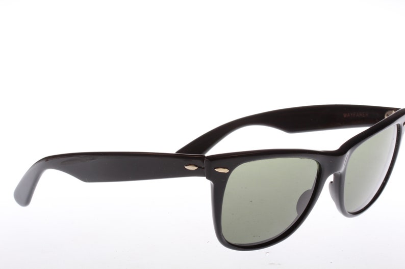 Peut inclure: Lunettes de soleil de style Wayfarer noires avec des verres verts.