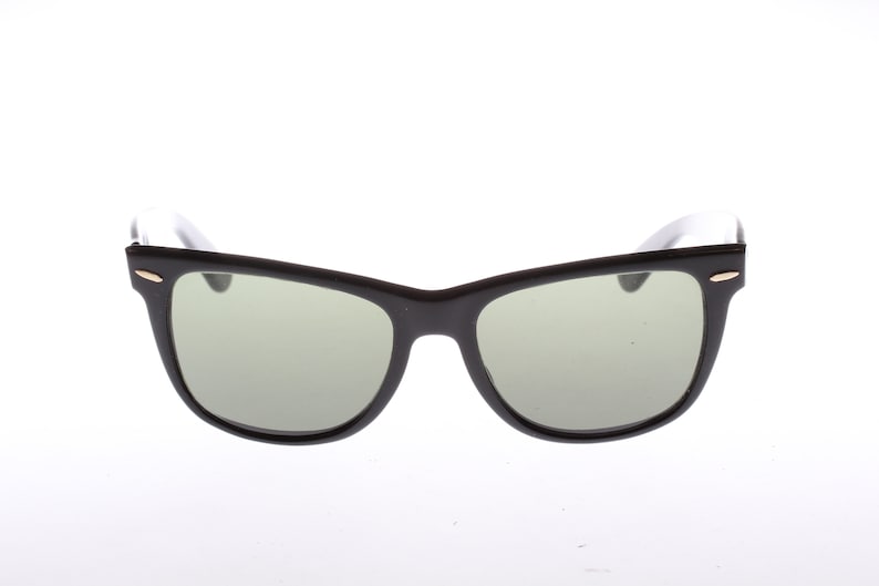 Peut inclure: Lunettes de soleil de style Wayfarer noires avec des verres verts.