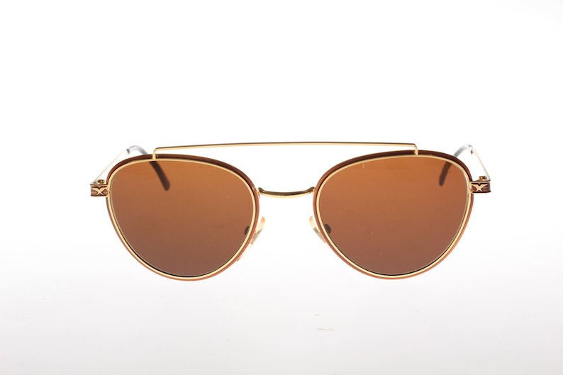 May include: Brown aviator sunglasses with a gold metal frame and brown lenses.