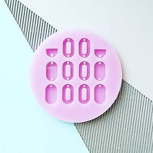 Puede incluir: Molde de silicona rosa con 10 formas diferentes para hacer joyas. El molde tiene forma redonda y presenta formas ovaladas y semicirculares.