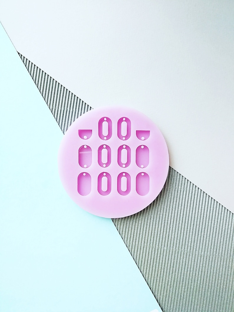 Puede incluir: Molde de silicona rosa con 10 formas diferentes para hacer joyas. El molde tiene forma redonda y presenta formas ovaladas y semicirculares.