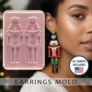 May include: A pink silicone earring mold with two nutcracker soldier designs. A woman wears a matching nutcracker earring with red, green, and black details. The text "EARRINGS MOLD" is at the bottom of the image.