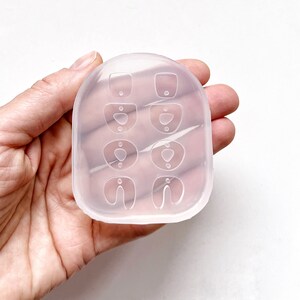 Puede incluir: Molde de silicona transparente con seis formas diferentes de pendientes. El molde est&aacute; dise&ntilde;ado para crear pendientes de varios estilos, incluyendo un c&iacute;rculo simple, una l&aacute;grima y una herradura.