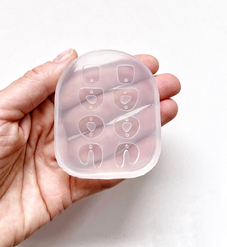 Puede incluir: Molde de silicona transparente con seis formas diferentes de pendientes. El molde est&aacute; dise&ntilde;ado para crear pendientes de varios estilos, incluyendo un c&iacute;rculo simple, una l&aacute;grima y una herradura.