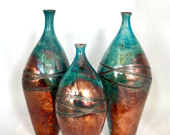 Botellas altas de turquesa con técnica raku y reducción de cobre, obra de Nathalie Hamill.