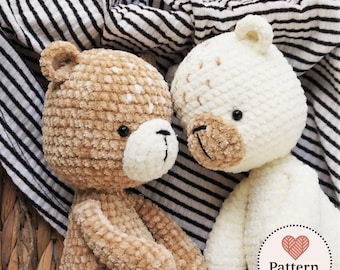 Può includere: Due orsetti di peluche all'uncinetto fatti a mano. Uno è marrone chiaro con macchie bianche, l'altro color crema. Entrambi hanno musetti color beige, occhi neri e sorrisi cuciti. Gli orsetti sono su uno sfondo a righe.