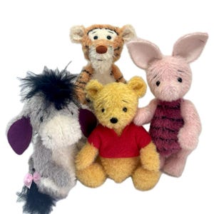 May include: A group of plush toys featuring characters from Hundred Acre Wood. The toys include a yellow bear in a red shirt, a pink pig, a tiger, and a gray donkey. The text "Hundred Acre Wood Friends 2025" is at the top.