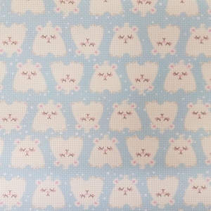 Peut inclure: Motif répétitif de figures blanches en forme d'ours aux yeux fermés et aux accents roses sur fond bleu clair. Les ours ont de petites oreilles roses et sont disposés en rangées, créant un design fantaisiste et mignon.