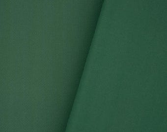 Puede incluir: Primer plano de una tela verde oscuro con una textura sutil. La tela está doblada por la mitad, mostrando ambos lados.