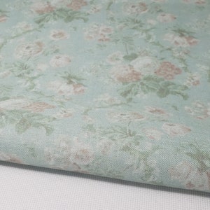 May include: A light blue fabric with a floral pattern. The fabric has a subtle texture and a vintage feel.