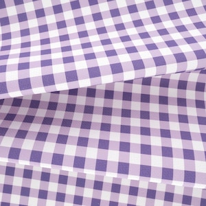 May include: A folded sheet of fabric featuring a repeating purple and white gingham check pattern. The material displays a consistent grid of small, square blocks in alternating colors, creating a classic checkered design across the surface.