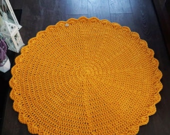 May include: A round, crocheted rug in a bright yellow color. The rug has a scalloped edge and is made with a simple stitch pattern.