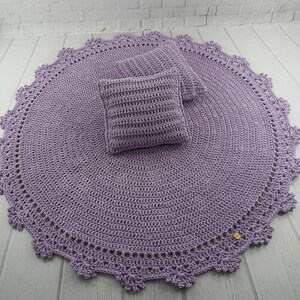 May include: A lavender crocheted round rug with a delicate lace border and two matching lavender crocheted cushions.
