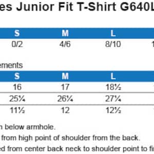 Op de afbeelding: Maattabel voor een junior fit t-shirt met metingen in inches voor de borst, lichaamslengte en mouwlengte. De maten omvatten S, M, L, XL en 2XL. De tabel bevat ook suggesties voor de maat voor elke maat.