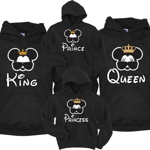 May include: Four black hoodies with a Mickey Mouse design. The hoodies have the words "King", "Queen", "Prince", and "Princess" on them. Each Mickey Mouse is wearing a gold crown and sunglasses.