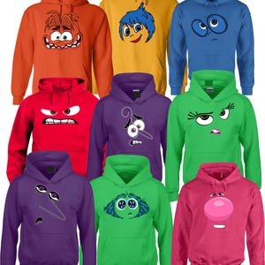May include: A collection of colorful hoodies featuring character faces from the animated movie. The hoodies are in various colors, including orange, yellow, blue, red, purple, green, and pink. Each hoodie has a unique character design.