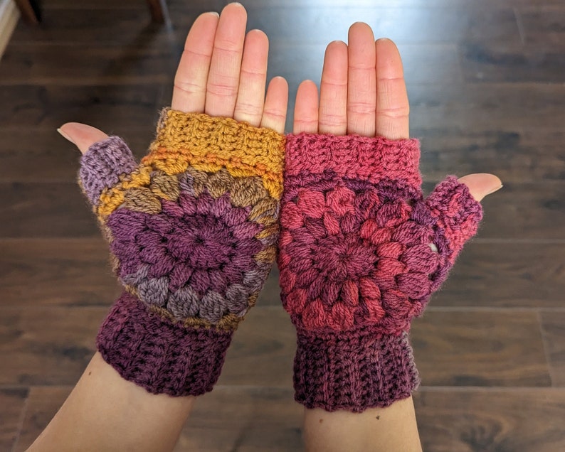 Peut inclure: Une paire de mitaines sans doigts avec un motif crochet&eacute;. Les mitaines sont faites avec un fil multicolore dans des tons de violet, rose, orange et jaune. Les mitaines ont un design sans doigts avec un trou pour le pouce.