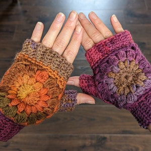 Peut inclure: Une paire de mitaines en crochet avec un motif floral color&eacute;. Les mitaines sont faites avec une vari&eacute;t&eacute; de nuances de marron, orange, violet et rose.