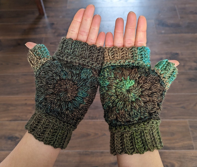 Peut inclure: Une paire de mitaines sans doigts de couleur marron, verte et bleue. Les mitaines pr&eacute;sentent un motif circulaire avec un tricot textur&eacute;.