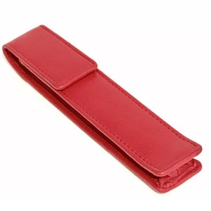 May include: A red leather pen case with a flap closure.