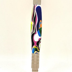 May include: A ballpoint pen featuring a barrel with a swirling, multi-colored pattern of blue, black, white, pink, green, and orange. The pen has a metallic silver tip, a textured silver grip section, and a silver click mechanism at the top.