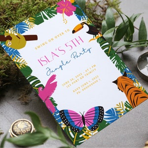 May include: A jungle-themed party invitation featuring a pink, blue, and yellow butterfly, a toucan, a sloth, a pink parrot, and a tiger. The invitation reads "Swing on over to Isla's 5th Jungle Party" with the date, time, and location.