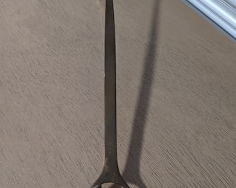 May include: A brass candle snuffer with a decorative design of a horse's head at the bottom.