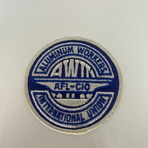 May include: A white and blue embroidered patch with the text "Aluminum Workers International Union AFL-CIO" in a circle.