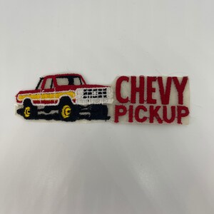 May include: Red and yellow embroidered patch featuring a cartoon image of a red Chevy pickup truck with the text "CHEVY PICKUP".