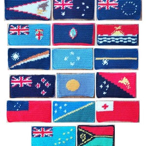 May include: A collection of rectangular crochet pieces, each featuring a flag design. The flags display various colors and patterns, including stars, stripes, and other symbols. The pieces are likely handmade and showcase a variety of national flags.