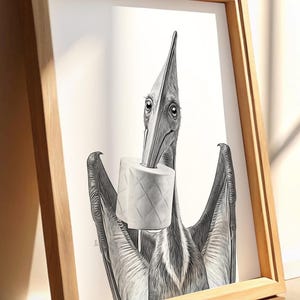 May include: Black and white framed art print featuring a pterodactyl holding a roll of toilet paper in its beak. The artwork is in a minimalist style, with a light brown wooden frame. The print is leaning against a wall on a wooden floor.