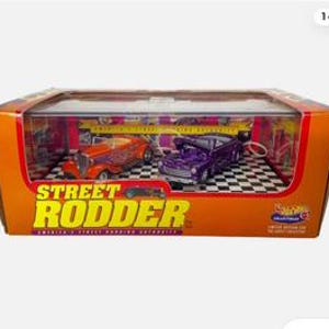 May include: A box containing two die-cast toy cars, a purple car and an orange car, with the words "Street Rodder" on the front of the box.