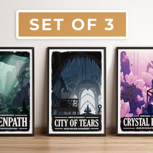 May include: Set of 3 framed art prints. Each print features a fantasy landscape with text: Greenpath, City of Tears, and Crystal Peak. The prints have black frames and are displayed on a wooden surface.