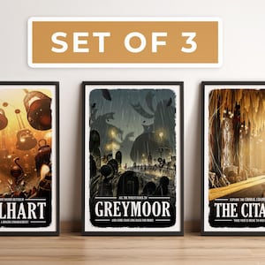 May include: Set of 3 framed art prints with fantasy-themed illustrations. Each print features a unique scene with the titles "Bellhart", "Greymoor", and "The Citadel". The prints are in black frames and are displayed on a wooden surface.