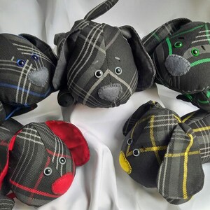 May include: A group of handmade dog plush toys. Each toy is made from black plaid fabric with red, yellow, green, and blue accents. The dogs have button eyes and felt noses.