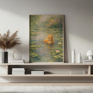 May include: A framed art print shows an orange tabby cat in a pond with lily pads and flowers. The artwork has a soft, impressionistic style, with muted greens, blues, and pinks. The cat is the focal point, appearing relaxed in the water.