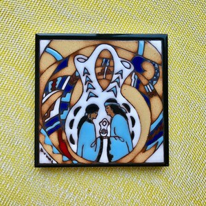 May include: A ceramic tile with a black frame features a colorful design of two figures in blue robes holding a white object. The background is a swirling pattern of blue, white, and brown.