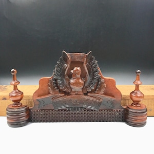 May include: A wooden eagle-shaped letter holder with a banner that reads "The Best". The holder has two decorative finials on either side and a patterned base.