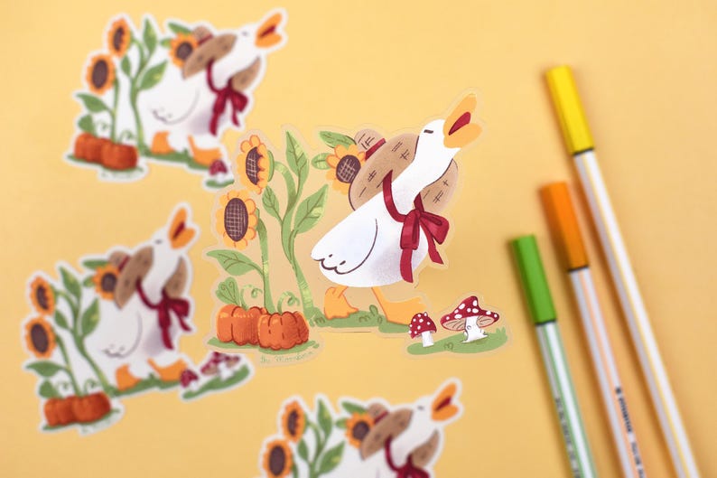 May include: A set of five stickers featuring a white goose carrying a basket of pumpkins and sunflowers. The stickers are on a yellow background with markers.