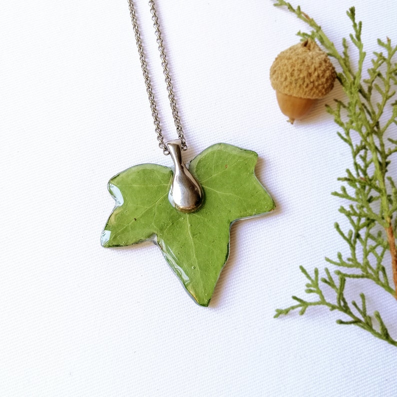 A lovely real leaf pendant appears on a luminous white background with a little plant. A wonderful piece of nature in this unique handmade creation. A touch of nature and elegance always around your neck. Magical spring inspiration.