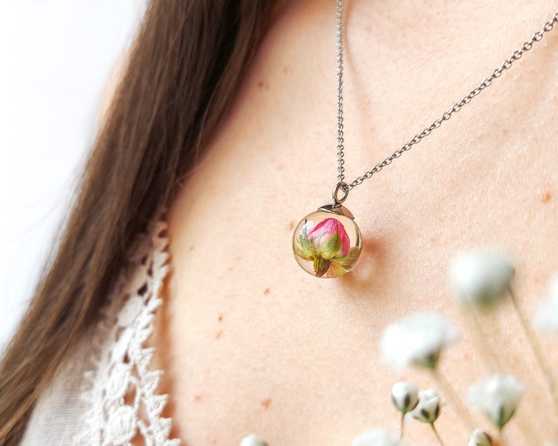 This beautiful creation appears on the model neckline with a real rose pendant inside. It is perfect to be worn with white clothes.