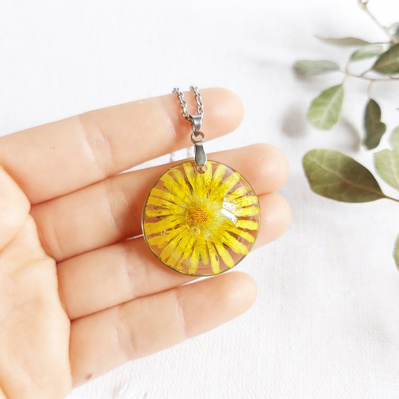 Unique handmade real flower necklace made of transparent resin inspired by the spring. Radiant crystal-clear pendant semi-spherical shaped inspired by the spring. Plated hypoallergenic stainless steel chain. Magical spring inspiration.