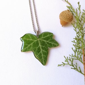 A cute real leaf collar appears on a luminous white background. Radiant crystalline necklace to have a piece of nature always with you. Customizable chain length. Magical nature inspiration in this handmade creation.