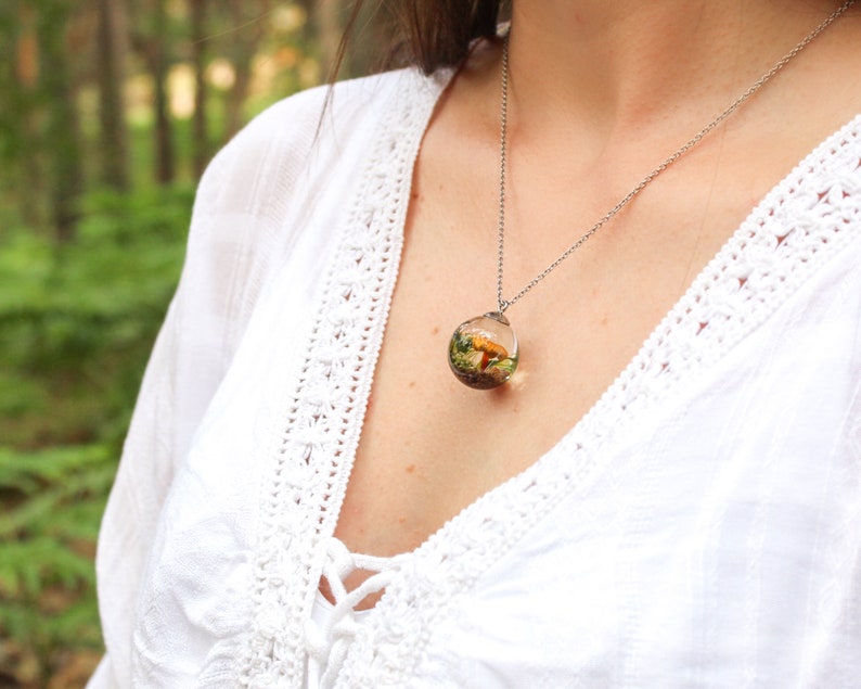 This beautiful creation appears on the model's neckline with a real mushroom inside. It is perfect to be worn with white clothes and give you an Ibizan touch.