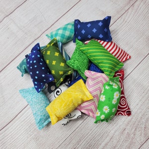 May include: A collection of 10 colorful fabric catnip toys. The toys are made of different fabrics and patterns, including polka dots, stripes, and flowers. The toys are all about 6 inches long and are perfect for cats to play with.