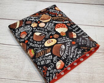 May include: A black fabric pouch with a red polka dot lining. The pouch is printed with a chocolate theme and includes text such as "Chocolate makes up for Mondays", "Just eat it", "I'd give up chocolate", "But I'm not a quitter", "How lucky I am to have chocolate in my life", and "Chocolate understands".