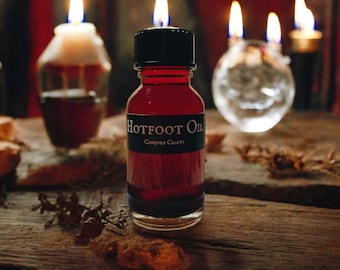May include: A small, dark red glass bottle with a black cap and a white label that reads "Hotfoot Oil" and "Conjure Crafts".