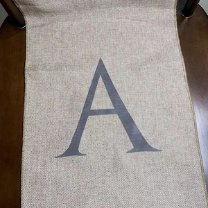 以下が含まれることがあります： グレーの文字「A」が印刷されたジュートの旗